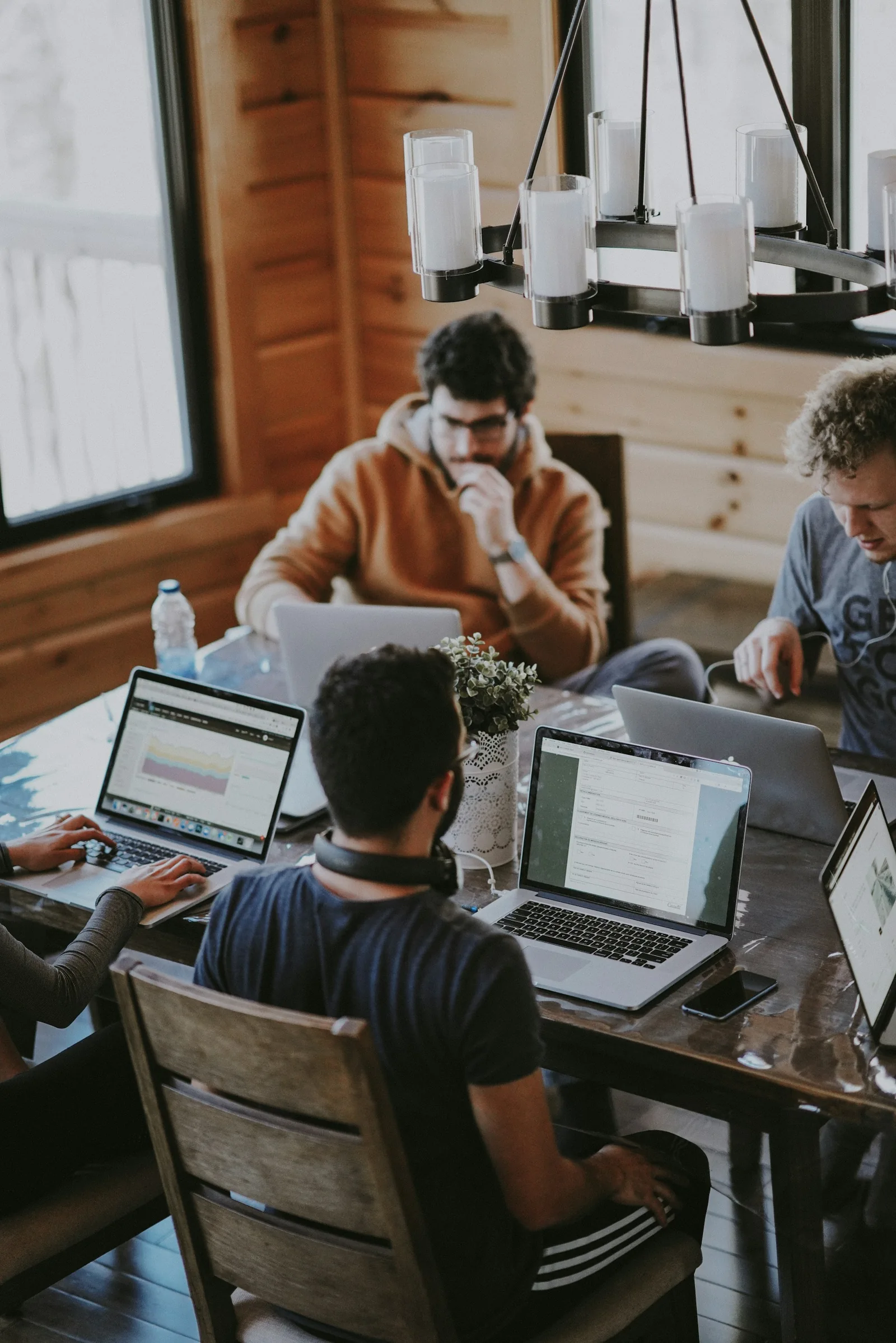 People collaborating around laptops in a creative workspace